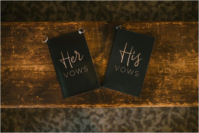 His and hers vow books sitting on antique wood bench